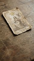 Vintage tarot card The Star on weathered wooden surface for fortune telling, divination and spiritual guidance practices.