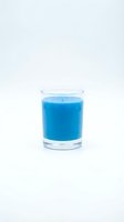 Glass of bright blue liquid drink on white background isolated for beverage design and health concept presentations.