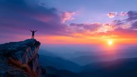 Silhouette of person with arms raised on mountain cliff edge against dramatic purple and orange sunset sky over misty mountain ranges.