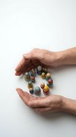 Protective hands surrounding colorful medication pills and capsules on white background representing healthcare safety and pharmaceutical care.