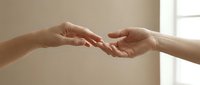 Two hands reaching toward each other against a soft neutral background, symbolizing connection, support, and human togetherness.