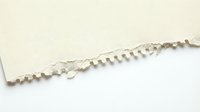 Torn beige paper edge with jagged rip detail on white background, suitable for design overlays, scrapbooking, and creative projects.