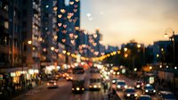Romantic heart-shaped bokeh lights illuminate urban street at sunset with blurred city traffic and warm golden hour glow creating dreamy atmosphere.
