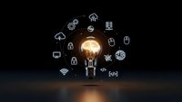 Glowing light bulb surrounded by technology icons on dark background representing innovation, creativity and digital transformation in business.