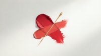 Red lipstick smear crossed out with wooden stick on white background. Makeup removal concept for beauty and cosmetics industry applications.