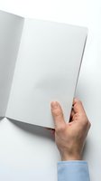 Hand holding open blank white book or magazine with empty pages on white background for mockup design and presentation purposes.
