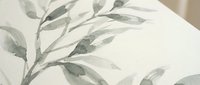 Soft botanical bedding with delicate green leaf pattern on white fabric creates serene bedroom atmosphere for home decor and interior design projects.