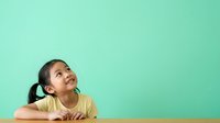Young girl with dark hair in ponytail, wearing yellow shirt, resting chin on hand against turquoise background, looking upward thoughtfully for educational and lifestyle content.