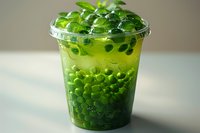Refreshing green bubble tea with tapioca pearls and jelly toppings in clear plastic cup, perfect for beverage menu, food photography, and summer drink promotions.