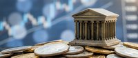 Miniature classical bank building with columns sits on golden coins against blurred financial charts background, symbolizing banking, investment and economic growth.