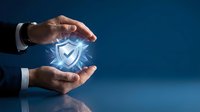 Businessman hands protecting glowing shield icon against blue background, representing cybersecurity, data protection, and digital safety for business and technology concepts.