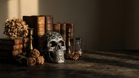 Dark gothic still life with ornate skull, vintage books, dried flowers and antique bottles on wooden table creating mysterious atmospheric scene.