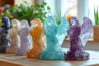 Colorful crystal angel figurines lined up on wooden surface, featuring turquoise, purple, orange and clear quartz specimens in spiritual home decor setting.