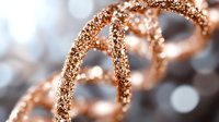 Sparkling rose gold DNA helix structure with glittering particles on blurred background, representing genetic science and biotechnology research.