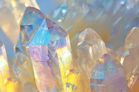 Iridescent rainbow crystal quartz cluster with holographic light reflections creating magical prismatic effects for spiritual healing and meditation practices.