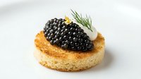 Gourmet pastry topped with creamy filling and luxurious black caviar garnish, isolated on white background for culinary, food styling, restaurant menu, and fine dining design projects.