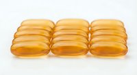 Golden omega-3 fish oil capsules arranged in rows on white background, dietary supplements for health and wellness nutrition support.