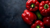 Fresh red bell peppers with water drops on dark background, raw organic produce for healthy cooking and vegetarian meals, macro food photography.