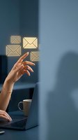 Woman with medium skin tone interacting with floating envelope icons above laptop, representing email communication, digital messaging, and business correspondence in modern workplace.