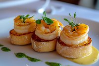 Grilled jumbo shrimp served on toasted baguette rounds with herb sauce and microgreens garnish, plated elegantly on white ceramic dish for fine dining presentation.