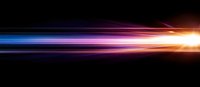 Vibrant light streaks in blue, purple and orange colors create dynamic motion effect against black background, radiating energy from bright focal point.