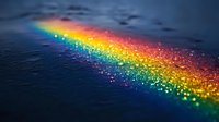 Vibrant rainbow spectrum reflected on dark water surface with magical glowing sparkles and bokeh light effects creating ethereal atmospheric scene.