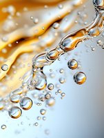 Macro photography of water drops and bubbles with golden light creating abstract pattern. Transparent spheres floating in liquid showing surface tension and reflection.