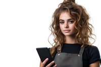 Young Caucasian woman with curly brown hair wearing gray apron and black t-shirt holding digital tablet against white background, professional service industry worker.