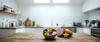 Modern kitchen interior with wooden countertop displaying fresh salad bowl and organic produce, bright natural light from skylight, white cabinetry and minimalist design for culinary and home decor projects.