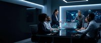 Diverse business team in futuristic conference room with holographic world map display during strategic planning meeting in modern corporate office.