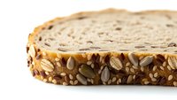 Artisan multigrain bread slice with sunflower seeds and mixed grains on white background, isolated for healthy food design projects and nutrition concepts.