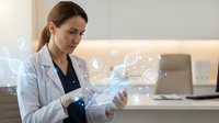 Professional female doctor in white coat using digital tablet with holographic medical data interface in modern healthcare facility.