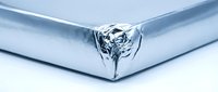 Shiny chrome metal corner edge with liquid mercury droplet forming at intersection point on reflective metallic surface for modern industrial design concepts.