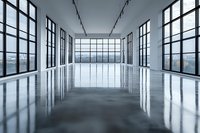 Empty modern open space interior with polished concrete floor, large industrial windows, and city view. Natural light illuminates minimalist architecture design.