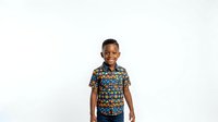 Young African boy wearing a colorful patterned short-sleeve shirt, standing against a white background. Suitable for children's fashion, retail, and educational materials.