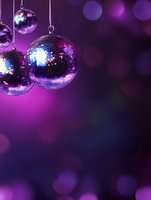 Shiny disco balls hanging against purple background with bokeh lights creating nostalgic retro party atmosphere for nightclub and entertainment designs.
