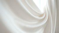 Soft white silk fabric with elegant flowing folds and gentle curves creating luxurious textile waves for fashion and interior design projects.