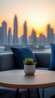Modern rooftop lounge setting with small potted succulent on round wooden table against blurred city skyline silhouette during golden sunset hour.
