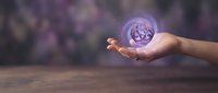 Hand holding glowing purple orb with recycling symbol floating above palm against blurred background for environmental sustainability concepts.