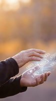 Close-up of male hands holding glowing digital circuit board interface with warm bokeh background, representing technology innovation, data processing, and future digital solutions.