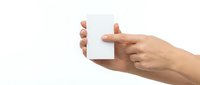 Hands holding blank white card isolated on white background, ready for design mockups, branding presentations, and business card templates.