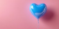 Blue heart-shaped balloon floating against pink background, creating romantic contrast for celebration or love-themed design.