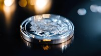 Silver dollar coin with detailed eagle design photographed in dramatic lighting with bokeh background, showcasing metallic texture and intricate engraving details.