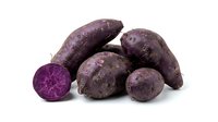 Purple potatoes isolated on white background, whole and sliced, showing vibrant interior color. Use for cooking, nutrition, healthy eating, food photography, recipe blogs, agricultural products, and culinary design projects.