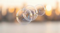Floating soap bubbles with rainbow reflections against warm golden bokeh background creating dreamy atmospheric scene for relaxation and mindfulness concepts.