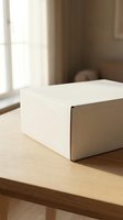 White cardboard shipping box on wooden table near window with natural light for e-commerce delivery and packaging needs.