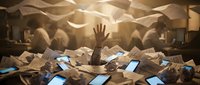 Person drowning in overwhelming pile of paperwork and documents with hand reaching up for help in office environment.