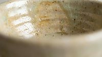 Dirty ceramic bowl with food residue and grease stains requiring cleaning and washing for kitchen hygiene maintenance.