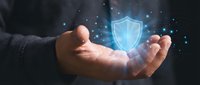 Businessman hands protecting glowing digital security shield with network connections for cybersecurity and data protection concepts.