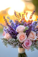 Romantic wedding bouquet with blush pink roses and purple lavender flowers against golden sunset bokeh background, wrapped with white ribbon at stem.